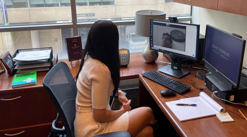 Katherine Chretien, MD, advises a student through videoconferencing software on her computer