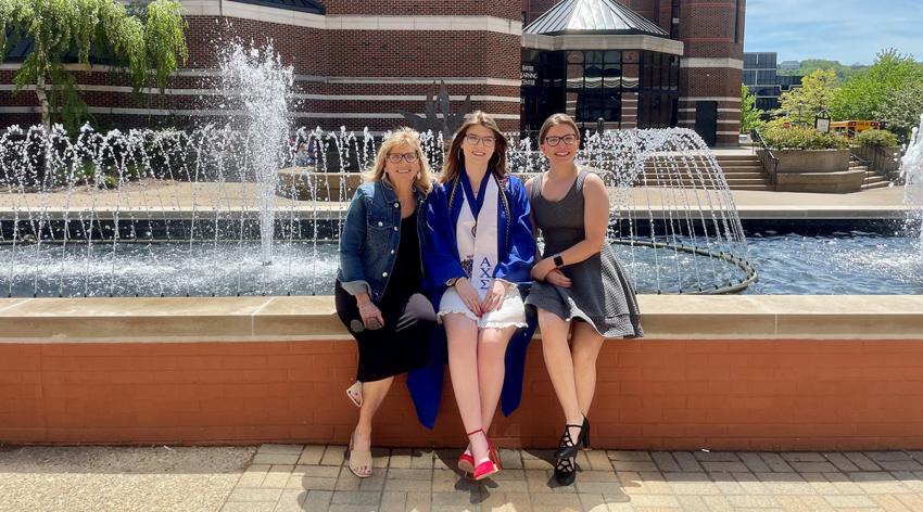 Jackie Duda, left, sits with her two daughters at her youngest daughter’s college graduation from Duquesne University in May 2023.