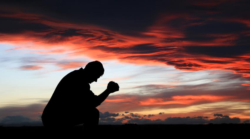 Silhouette of middle-aged man praying