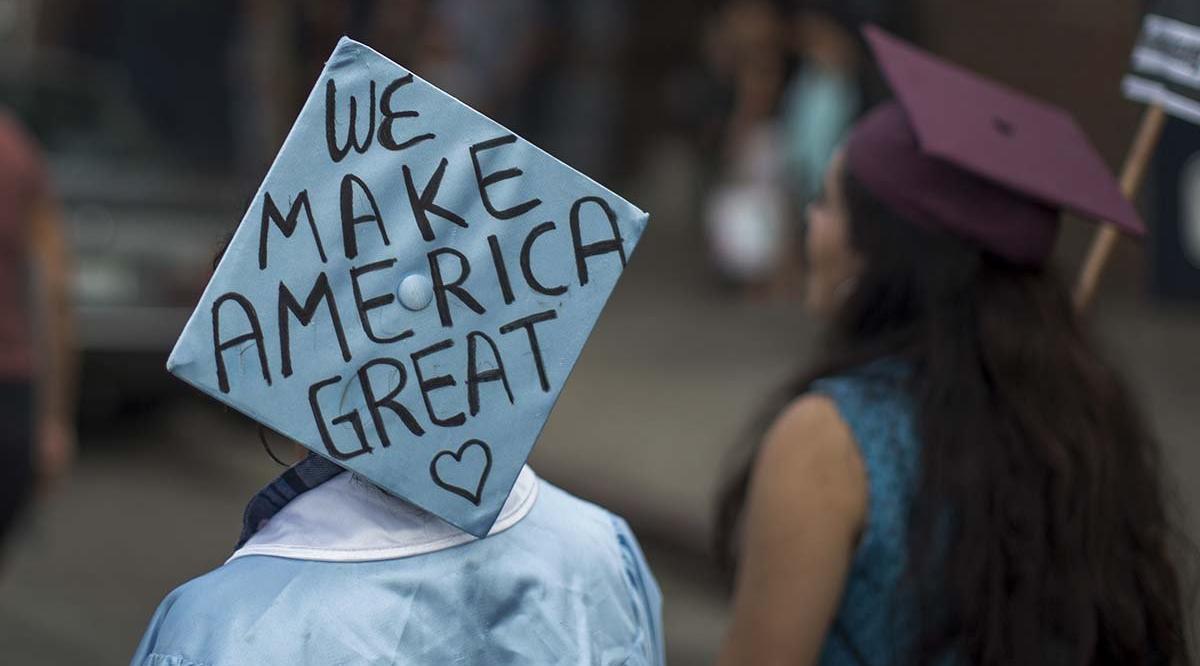 college graduate with a cap reading we make america great