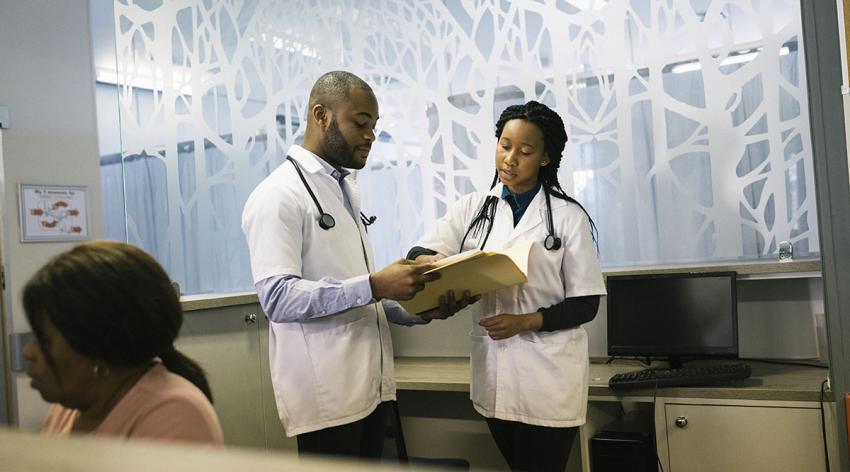 Two medical students confer in a room