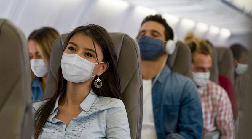 A group of masked travelers on a plane