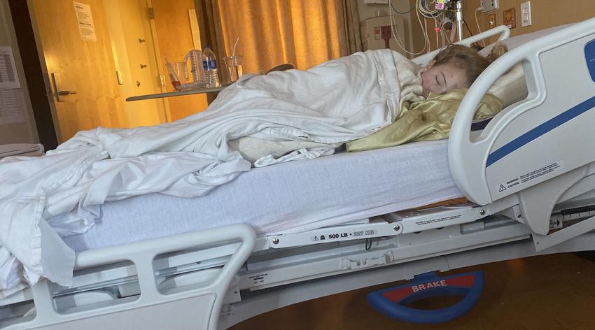Colorado 17-year-old Lilly Downs lies in a hospital bed.