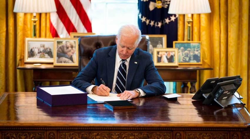Biden at desk signing bill