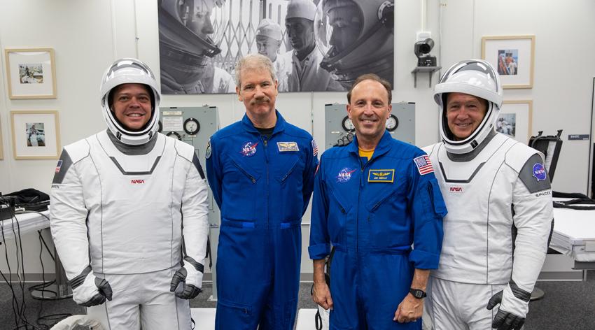Astronauts Bob Behnken and Doug Hurley pose for a photo at Kennedy Space Center in Cape Canaveral, Florida prior to the NASA/SpaceX launch of the first Commercial Crew mission May 30, 2020. Posing in blue flight suits are NASA flight surgeons Joe Dervay, MD, right, and Steve Hart, MD, left.