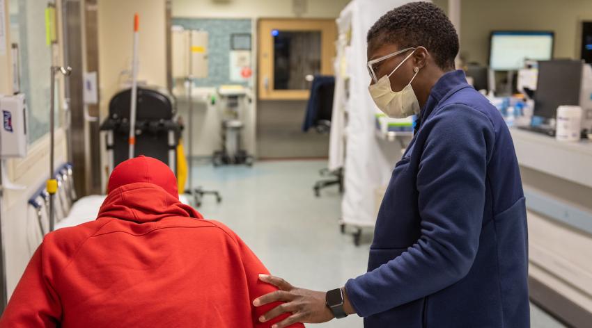 Adrianne Haggins, MD, tends to a patient at the University of Michigan Health emergency department in Ann Arbor.