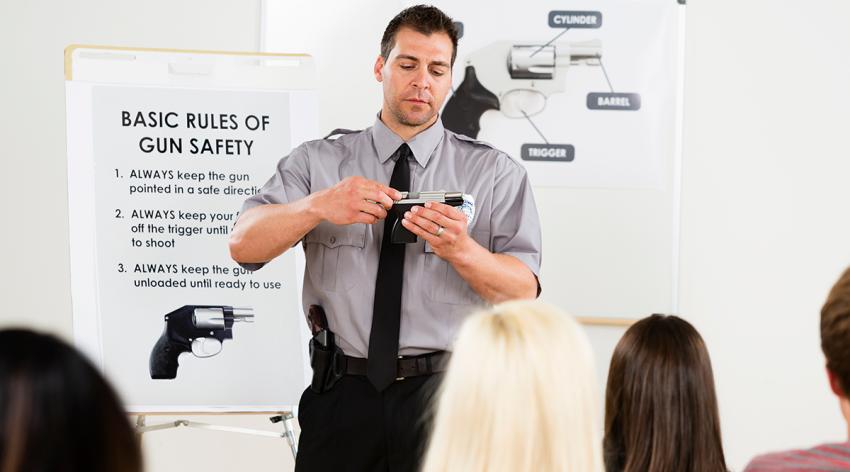 An instructor teaching a gun safety class to a group of students.