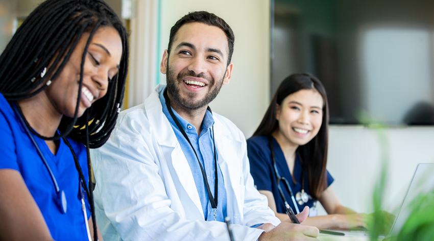 Medical students smile during meeting in conference room