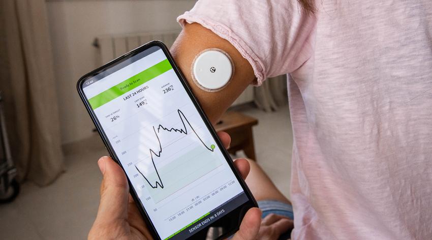 Continuous Glucose Monitoring (CGM) system with sensor attached in arm controlling information and alerts with mobile phone app.